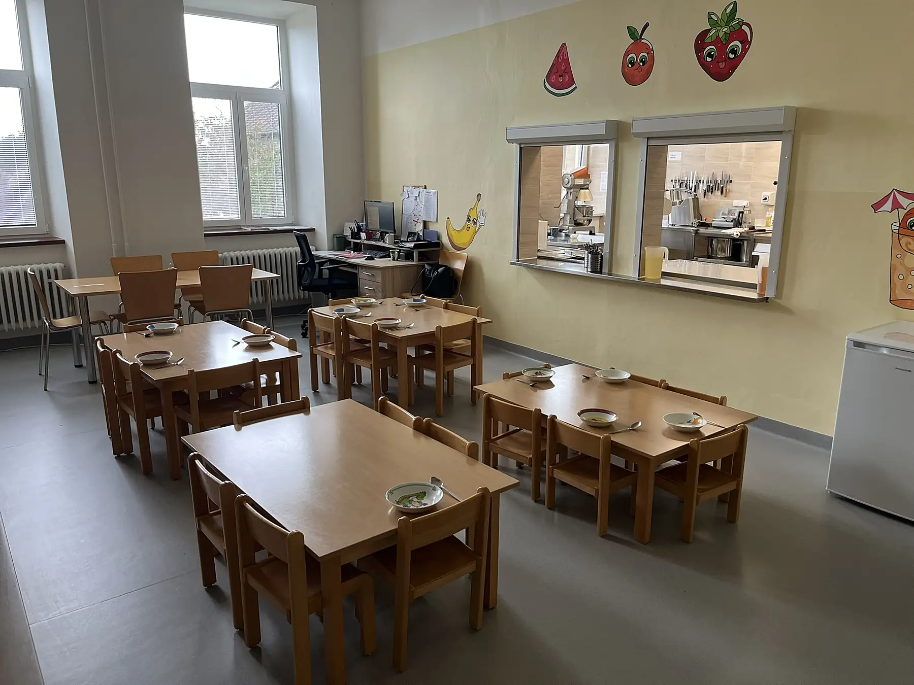 Jídelna s dřevěnými stoly a židlemi