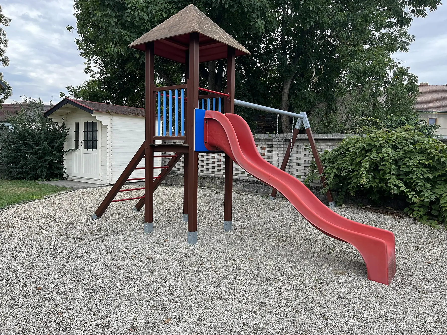 Dřevěná věž se skluzavkou na zahradě školky